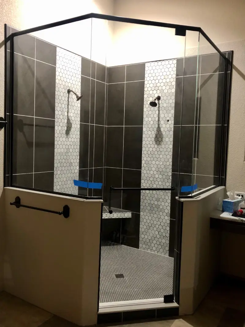 A bathroom with two shower stalls and a tiled floor.
