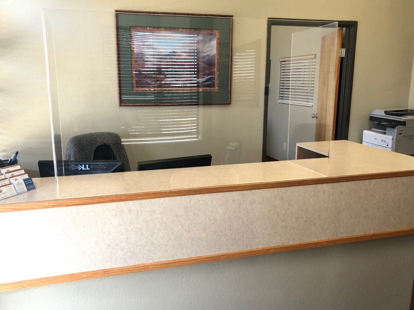 A reception desk with a chair and a window