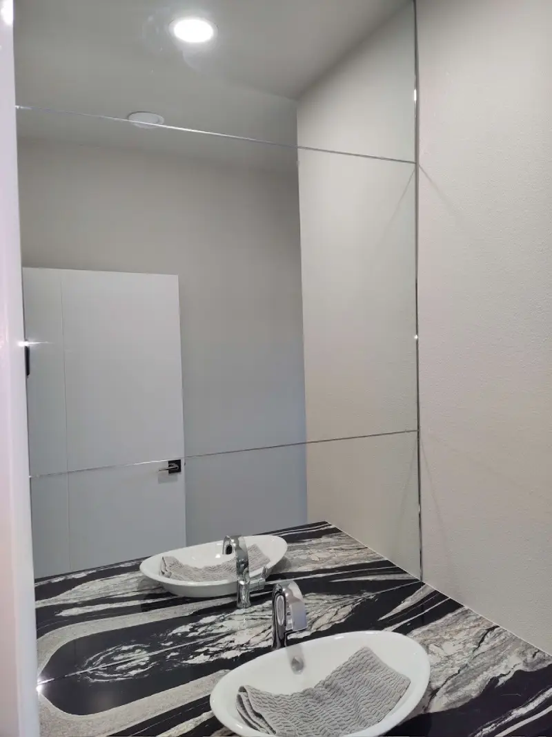 A bathroom with a sink and mirror in it