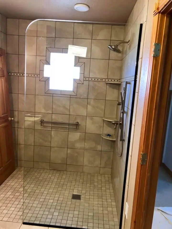 A bathroom with a walk in shower and tiled walls.
